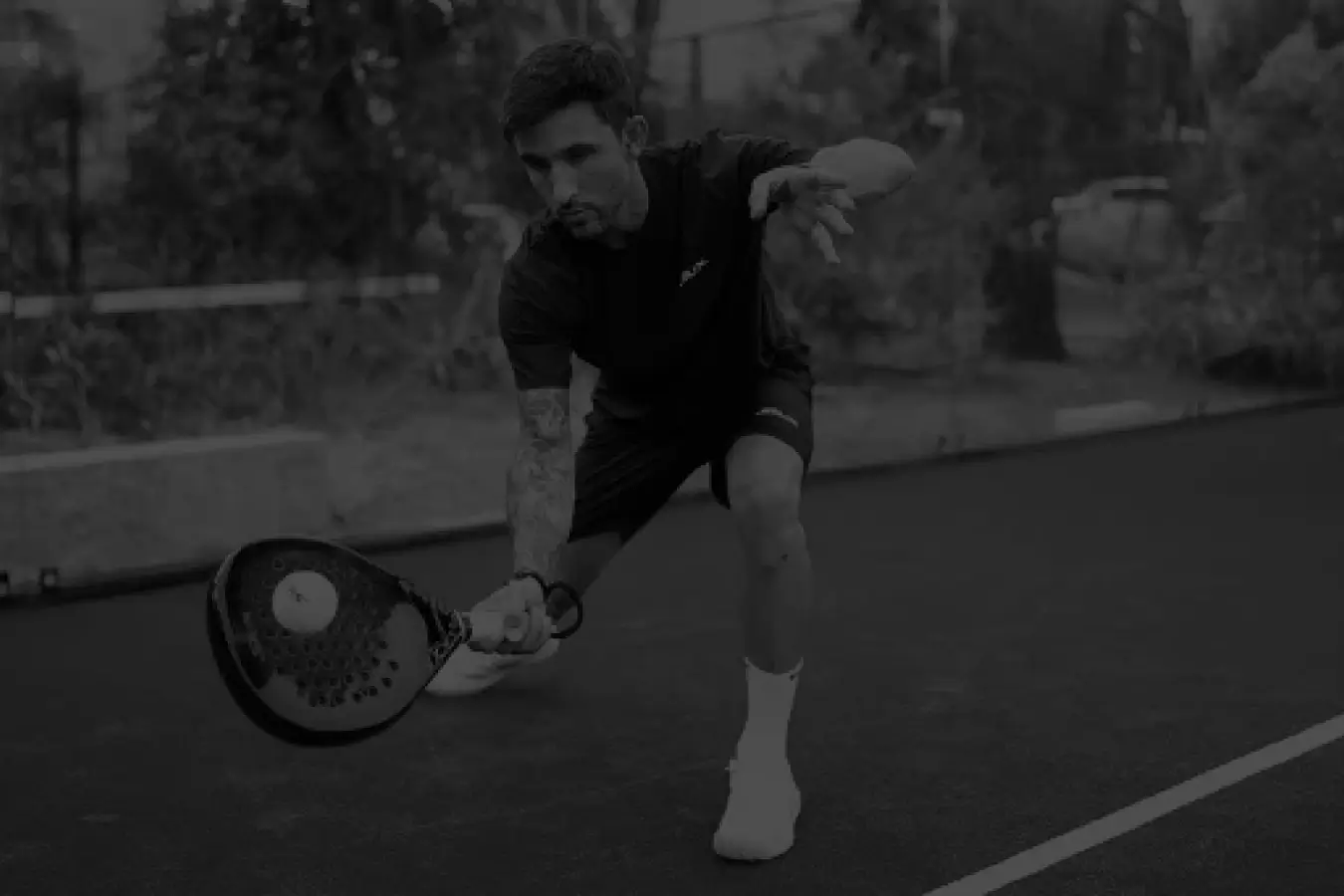 Padel player executing a controlled lob shot, aiming to send the ball high over the opponents.