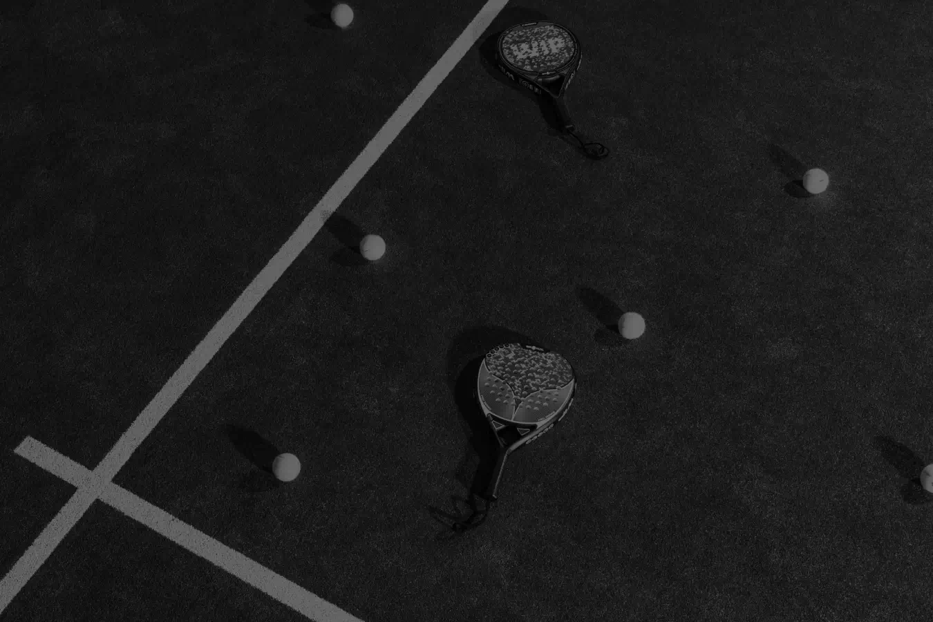 Padel court black and white balls and padel rackets on the court