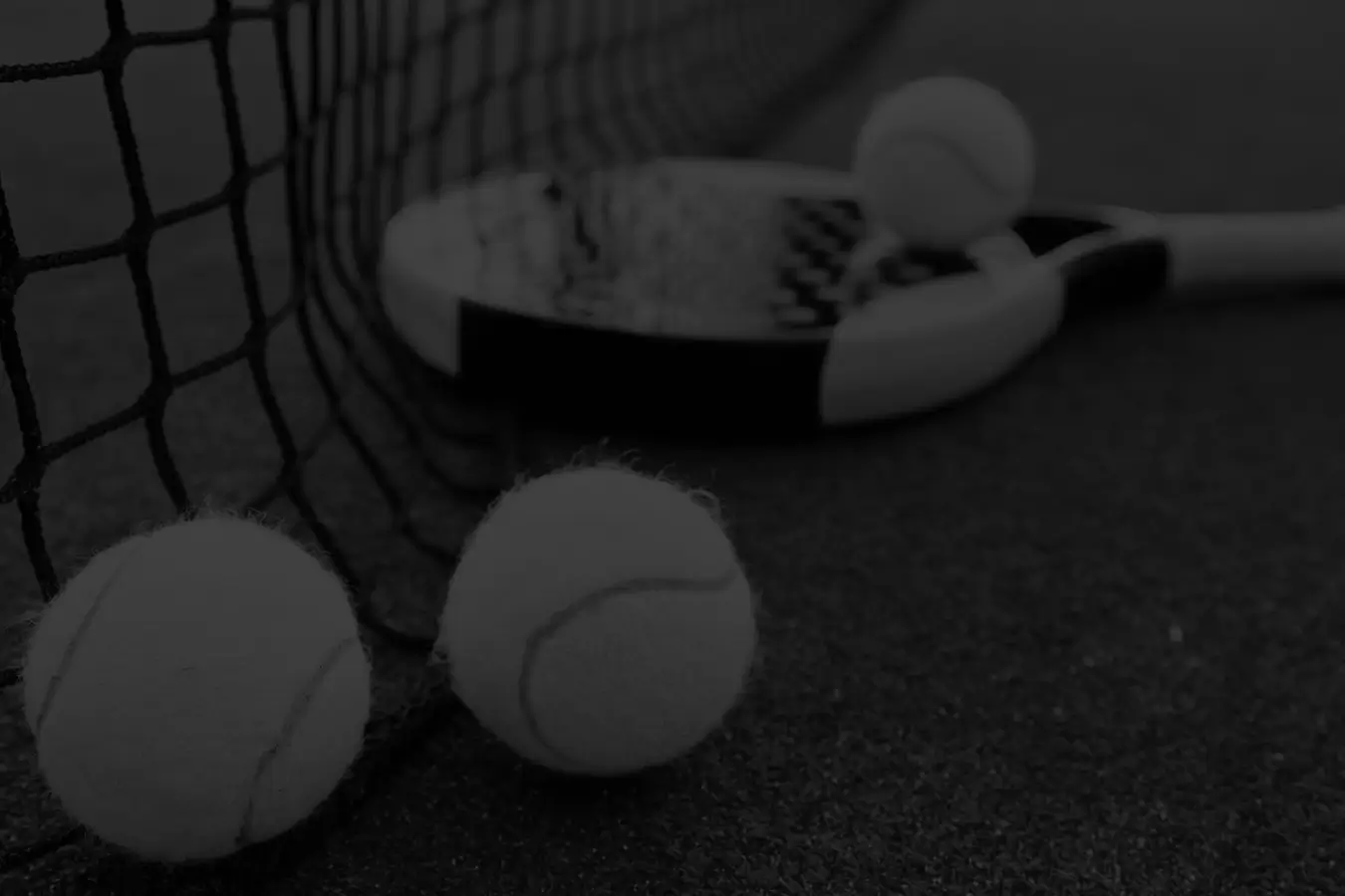 padel balls and racket on the padel court against the net in black and white